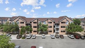 Albuquerque apartment for rent - A parking lot in front of a building with cars parked.