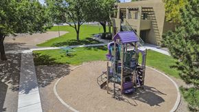 Albuquerque apartment for rent - A playground with a purple slide and a round sandbox.