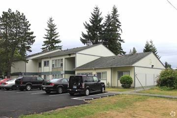 Everett apartment for rent - A parking lot with cars and a building in the background.