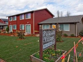 Roseburg apartment for rent - A sign that says Parkside Village stands in front of a building.