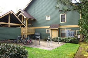 Sandy apartment for rent - a green house with bikes parked outside of it