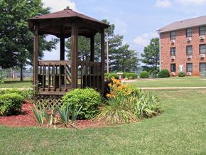 Russellville apartment for rent - a gazebo surrounded by plants in the courtyard of Village Square Apartments in Russellville, AL