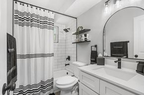 Sarasota apartment for rent - A white bathroom with a black and white shower curtain.