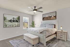 Cordova apartment for rent - a large bedroom with plush carpeting, ceiling fan, window, and virtual furnishings at Rock Creek Apartments in Cordova, TN
