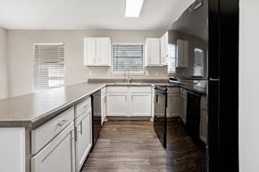 Bessemer apartment for rent - A kitchen with white cabinets and a black refrigerator.