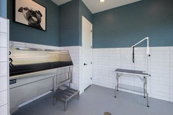 A laundry room with a sink and ironing board