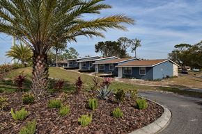Cocoa apartment for rent - a row of blue bungalow apartments with palm trees at The Sands on Clearlake