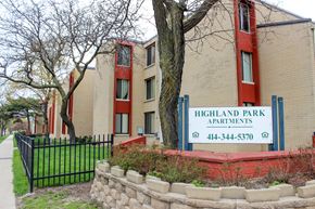 Milwaukee apartment for rent - A sign for Highland Park Apartments is in front of a brick building.