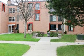 Milwaukee apartment for rent - A red brick building with a tree in front.