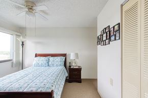 Orlando apartment for rent - bedroom with large window, ceiling fan, closet, and model furnishings