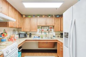Orlando apartment for rent - kitchen with oven/stove, fridge, wood cabinets, and overhead lighting
