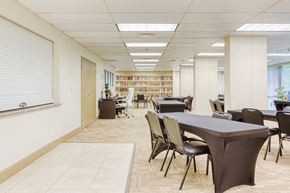 Orlando apartment for rent - large community room with tables and chairs by computer station & library