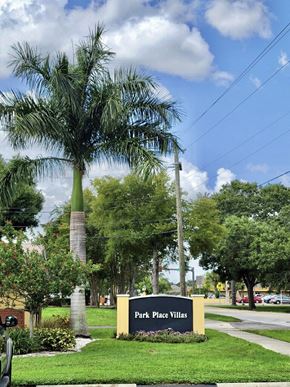 Sarasota apartment for rent - Park Place Villas sign with towering palm tree and lush landscaping