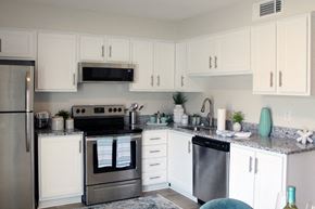 Huntsville apartment for rent - kitchen with white cabinets, granite countertops, and stainless steel appliances and built-in microwave  at Huntsville Landing Apartments, Huntsville, AL