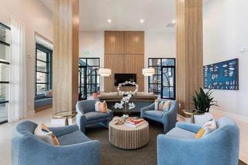 Orlando apartment for rent - A modern living room with blue chairs and a coffee table.