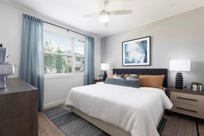 Orlando apartment for rent - A bedroom with a large bed, a nightstand, and a ceiling fan.