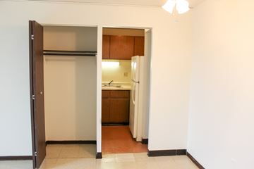 Milwaukee apartment for rent - A kitchen area with a refrigerator and wooden cabinets.