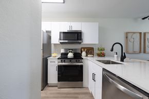 West Palm Beach apartment for rent - A modern kitchen with white cabinets and stainless steel appliances.