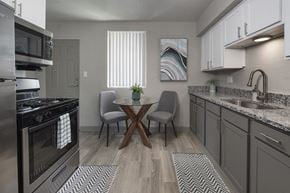 Clearwater apartment for rent - Kitchen with granite countertops, stainless steel appliances, and wood-style floors at Terraces at Clearwater Beach, Clearwater, 33756