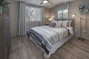 Clearwater apartment for rent - Bedroom with two large windows, fan, wood-style floor, and model furnishings at Terraces at Clearwater Beach, Florida