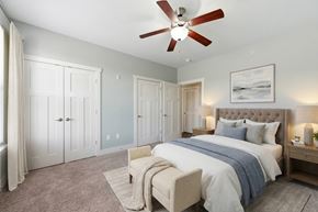Huntsville apartment for rent - A bedroom with a large bed and a ceiling fan.