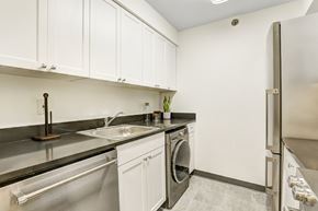 Hoboken apartment for rent - a kitchen with white cabinets and stainless steel appliances and a sink