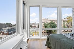 Jersey City apartment for rent - a bedroom with large windows and a bed and a city view