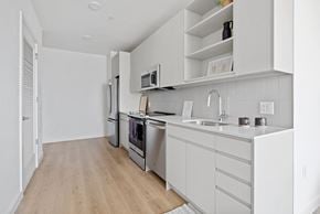 Jersey City apartment for rent - a kitchen with white cabinets and stainless steel appliances