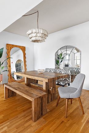 Hoboken apartment for rent - a dining room with a wooden table and bench and a chandelier
