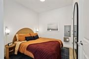 Jersey City apartment for rent - a bed in a hotel room with a red blanket and orange pillows