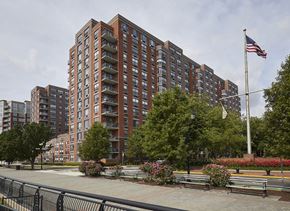 Hoboken apartment for rent - a large apartment building with a american flag in front of it