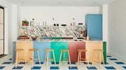 Jersey City apartment for rent - a colorful kitchen with bar stools and a counter with a blue refrigerator