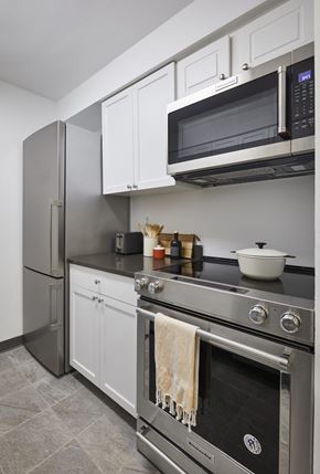 Hoboken apartment for rent - a kitchen with white cabinets and stainless steel appliances