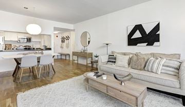 Hoboken apartment for rent - A modern living room with a grey sofa and a wooden coffee table.