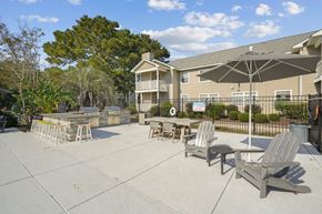 Wilmington apartment for rent - A patio with chairs and an umbrella in front of a building.