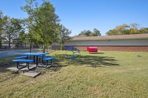 New Bern apartment for rent - A playground with a blue swing set and a red slide.