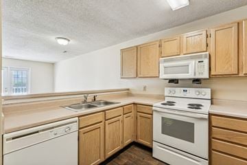 New Bern apartment for rent - A kitchen with a white stove and wooden cabinets.