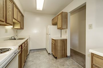 Waldorf apartment for rent - A kitchen with wooden cabinets and a white refrigerator.