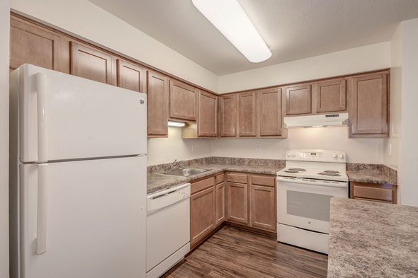 Waldorf apartment for rent - a kitchen with wooden cabinets and white appliances