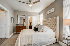 Sandy apartment for rent - A bedroom with a large bed and a ceiling fan.
