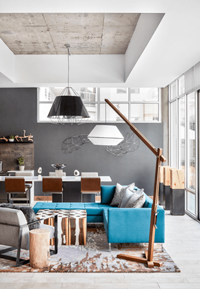 Denver apartment for rent - A living room with a blue couch and a wooden floor lamp.