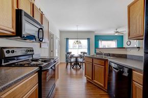 Greensboro apartment for rent - A kitchen with wooden cabinets and a black stove top oven at Ethan Pointe Apartments, Greensboro, NC, 27215