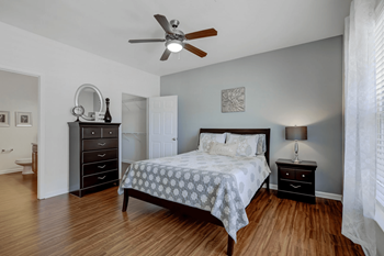 A bedroom with a bed, dresser, and mirror.
