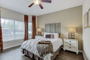 Louisville apartment for rent - a bedroom with a large bed and a ceiling fan