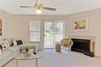 A living room with a fireplace, a couch, a chair, and a table.