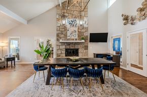 Marietta apartment for rent - A dining room with a stone fireplace and a large table surrounded by chairs.