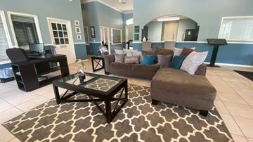 Orlando apartment for rent - A living room with a brown couch and a glass coffee table.
