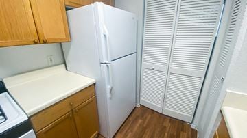 Clermont apartment for rent - A white refrigerator is in a kitchen with wooden cabinets.