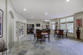 Tyler apartment for rent - Clubhouse interior with dining area, clubhouse kitchen, hanging lights and fitness center in background