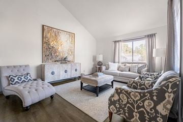 Savannah apartment for rent - A living room with a grey sofa, a white chair, and a large painting on the wall.